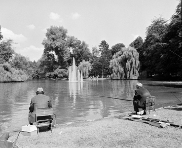 857856 Afbeelding van twee vissende mannen bij de vijver in het Wilhelminapark te Utrecht.